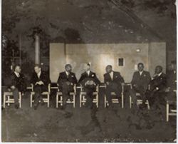 President William V. S. Tubman sits with other officials in a row