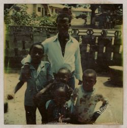 Man and four children pose for portrait on patio