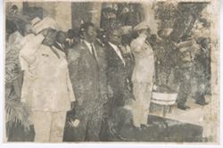 President William V. S. Tubman stands in group with saluting military men