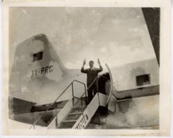 Man stands at top of stairs leading to airplane
