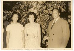 Minister of Industry and Commerce Mr. N'Doure stands with two women outdoors