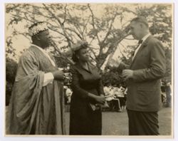 Man in suit speaks to Mrs. Tubman and a man in traditional dress