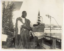 Man in traditional dress makes speech at podium