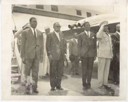President William V. S. Tubman and officials stand by airplane on runway