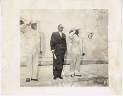 President William V. S. Tubman stands in front of a ship with two military officials