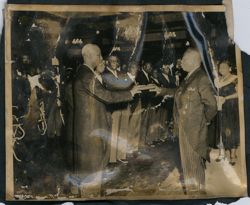 President Tubman and a dignitary hold a book as a part of a ceremony