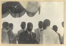 Men stand together under awning