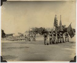 Military officals march with flags and lead troops