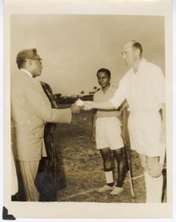 Exchange of gift between Ambassador C. T. O. King and field hockey player