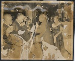 President Tubman holds a  book out for a dignitary to kiss
