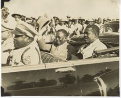 President William V. S. Tubman and officials ride in car as it passes crowd during parade