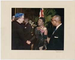 Portrait of women shaking hands as President William V. S. Tubman greets guest in background