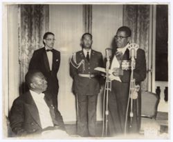President Tubman looks on as President of Haiti speaks into a microphone