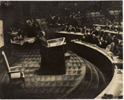 Standing in the podium spotlight, President William V. S. Tubman addresses a crowd of dignitaries
