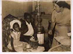 Woman speaks with Coocoo Tubman as she sits by Mrs. Tubman