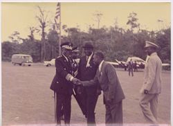 President William V. S. Tubman in military garb greets man in business attire on airstrip