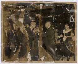 President Tubman holds up book for a dignitary to kiss
