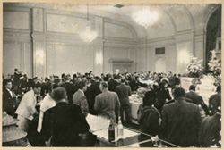 Guests mingle in a large reception room with bar and buffet tables