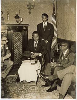President William V. S. Tubman sits with officials over drinks