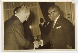 President William V. S. Tubman shakes hands with guest at a reception