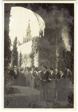 President Tubman stands with dignitaries in a garden with the Seville Cathedral in the background
