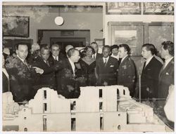 Man explains a model of ruins to President Tubman and other dignitaries