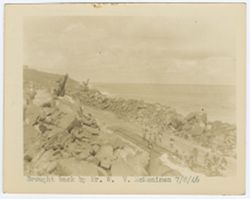 Workers around quarry tracks, machinery in the background