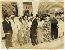Guests in traditional and formal attire gather outside