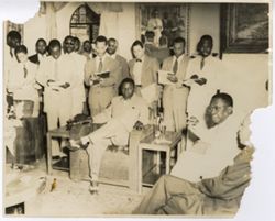 President William V. S. Tubman sits with officials with group of men look on