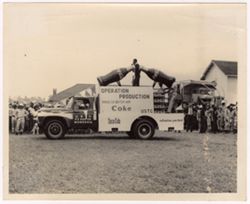 A Coca-Cola truck drives past a crowd