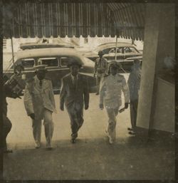 Men walk together under awning