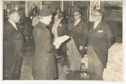 President William V. S. Tubman stands with man in traditional dress holding paper in hands