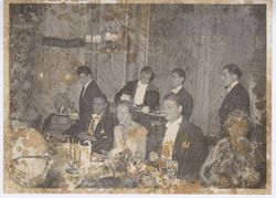 Servers lining up behind guests at formal dinner