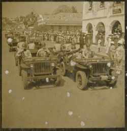 Military men drive vehicles in parade