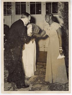 Man in formal attire greeting woman in reception line
