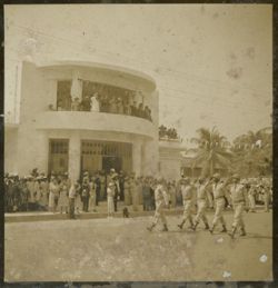 Military men march in parade and salute the crowds in front of Executive Pavilion