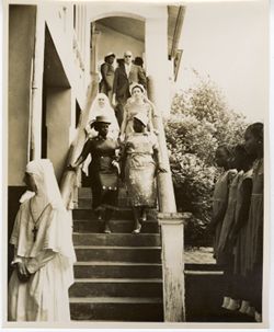 Mrs. Tubman walks down stairs with two women and a nun while a line of children wait at the bottom