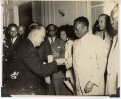 Official hands President William V. S. Tubman gift during reception