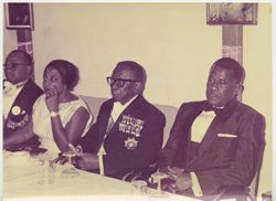 President Tubman and others in formal attire seated at reception table