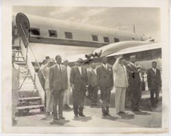 President William V. S. Tubman and officials stand on runway in front of airplane