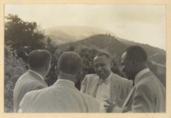Four men stand together outside