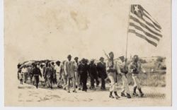 Men marching behind military officials