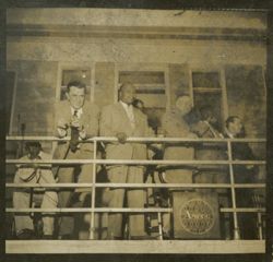 President Tubman stands with dignitaries on a balcony