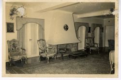 Interior room with upholstered chairs and large fireplace