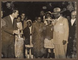 President Tubman and his family look on as a man explains an artifact