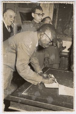 President Tubman signs a book in or near Toledo, Spain