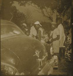 Group gathers around automobile