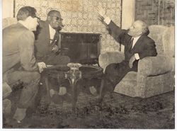 President Tubman listening to companions around table