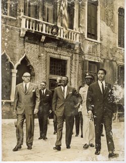 President William V. S. Tubman walks with officials outdoors