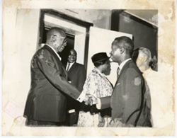 President William V. S. Tubman shakes hand with man in business suits
